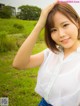 A woman in a white shirt and blue skirt posing for a picture.