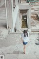 A woman standing on the ground in front of a building.