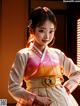 A woman in a korean dress standing in front of a window.